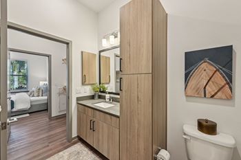 A bathroom with a wooden vanity and a toilet.